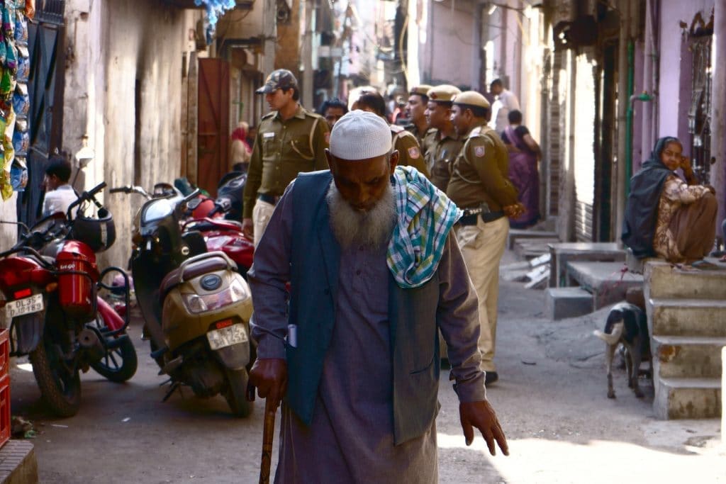 A Muslim elderly man walking away from Police